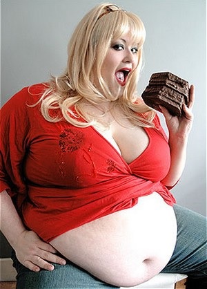 Полная женщина ест пироженое