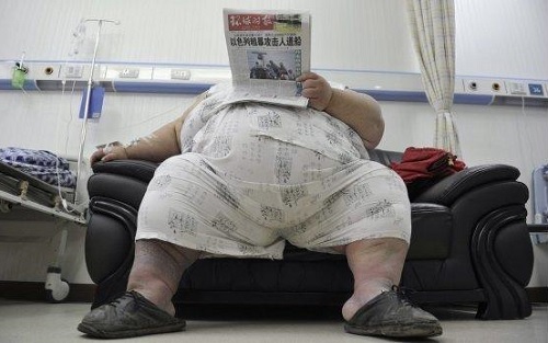 Тучная женщина читает газету