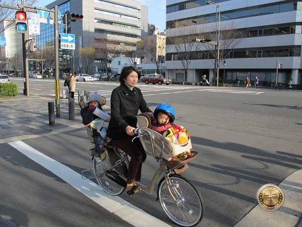 Мама с двумя детьми на велосипеде